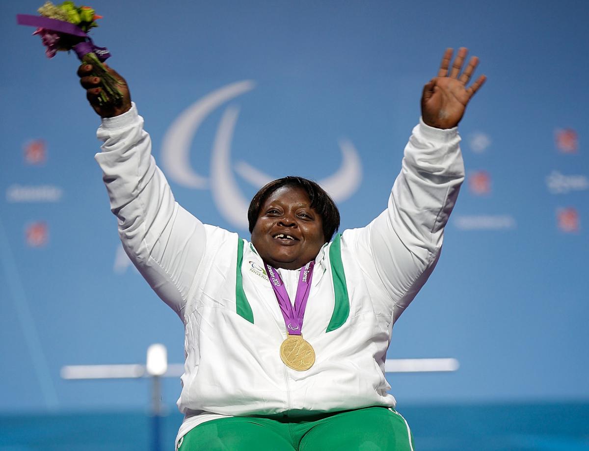 A picture of a woman on a podium with a medal around her neck