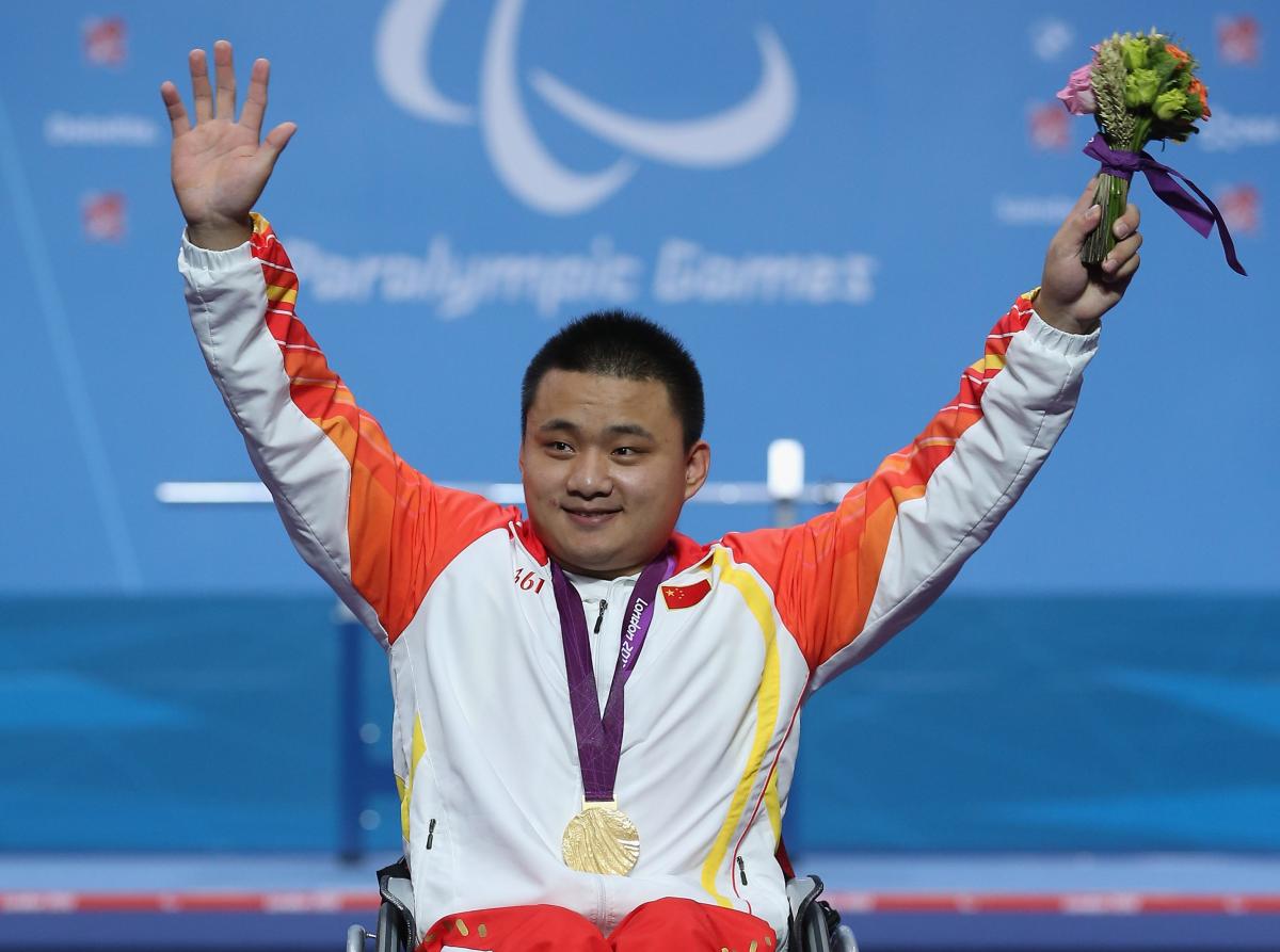 A picture of a man on a podium with a medal around his neck