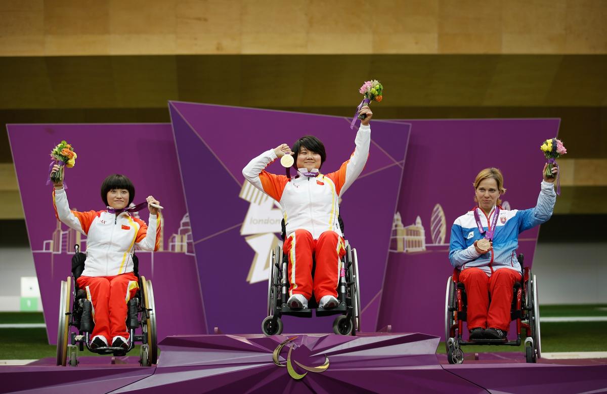 A picture of women on a podium with medals around their neck