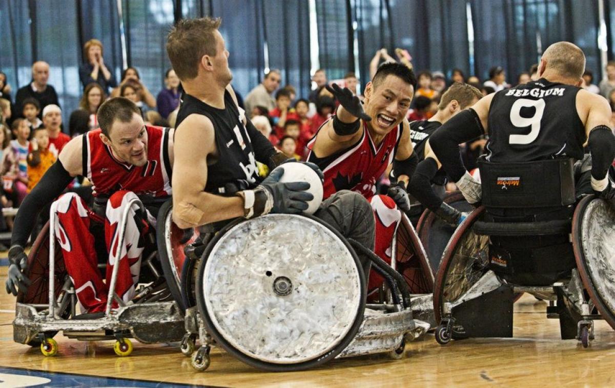 Belgium wheelchair rugby player defends ball against canadian player