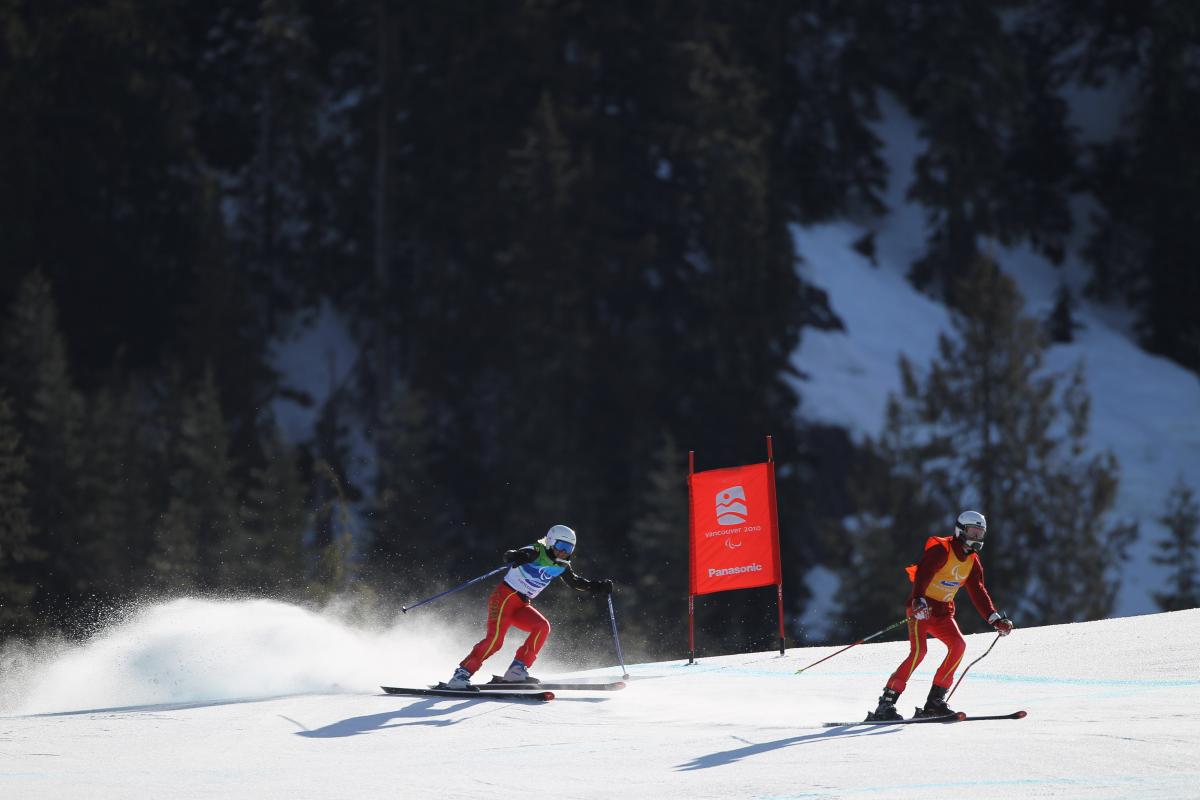 Natasha de Troyer of Belgium and guide Diego van de Voorde compete in the Women's Visually Impaired Downhill during Day 7 of the 2010 Vancouver Winter Paralympics