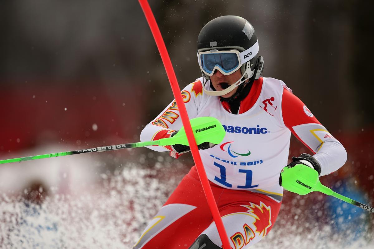 Mac Marcoux in a close-up focussing on the slalom pole in front of him