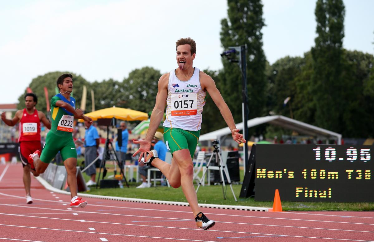 Man crossing a finish line in a stadium, celebrating