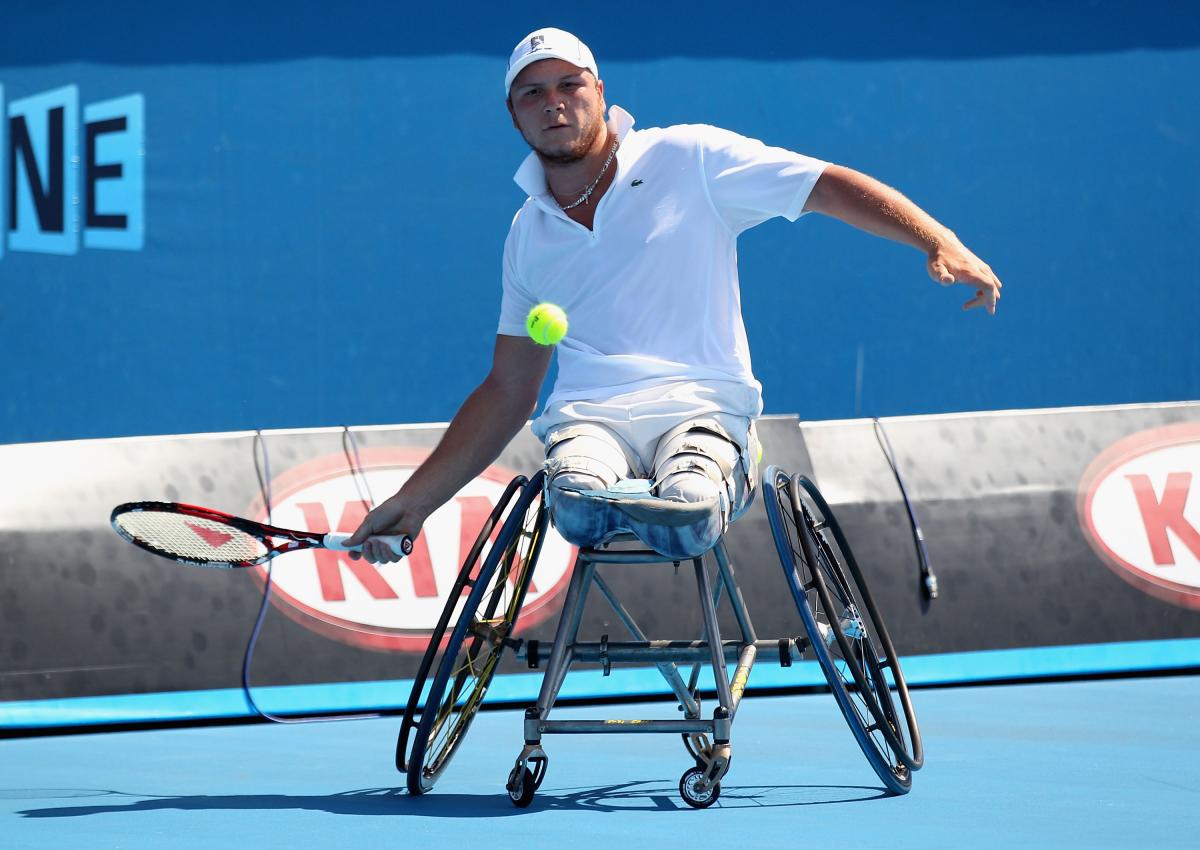 Nicolas Peifer A wheelchair tennis player hits a forehand with his right hand.