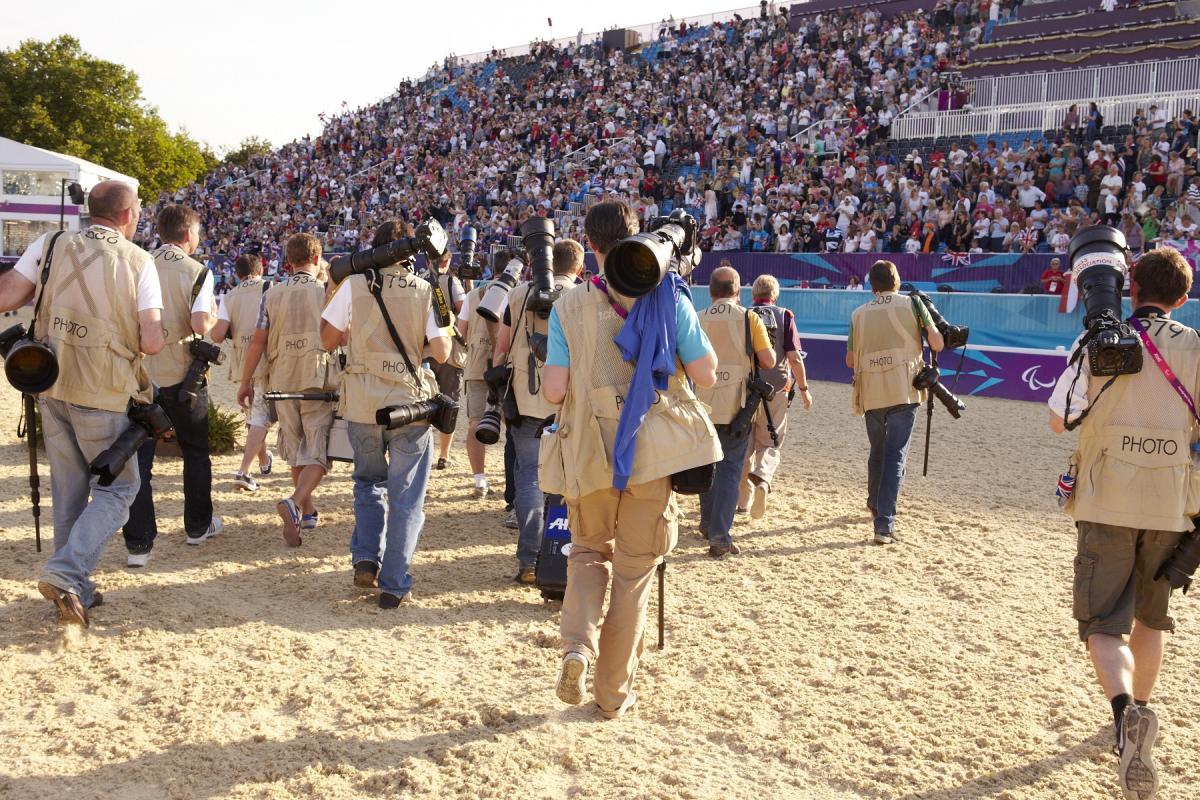 Equestrian photographers A group of photographers' backs are shown as the walk across an equestrian venue.