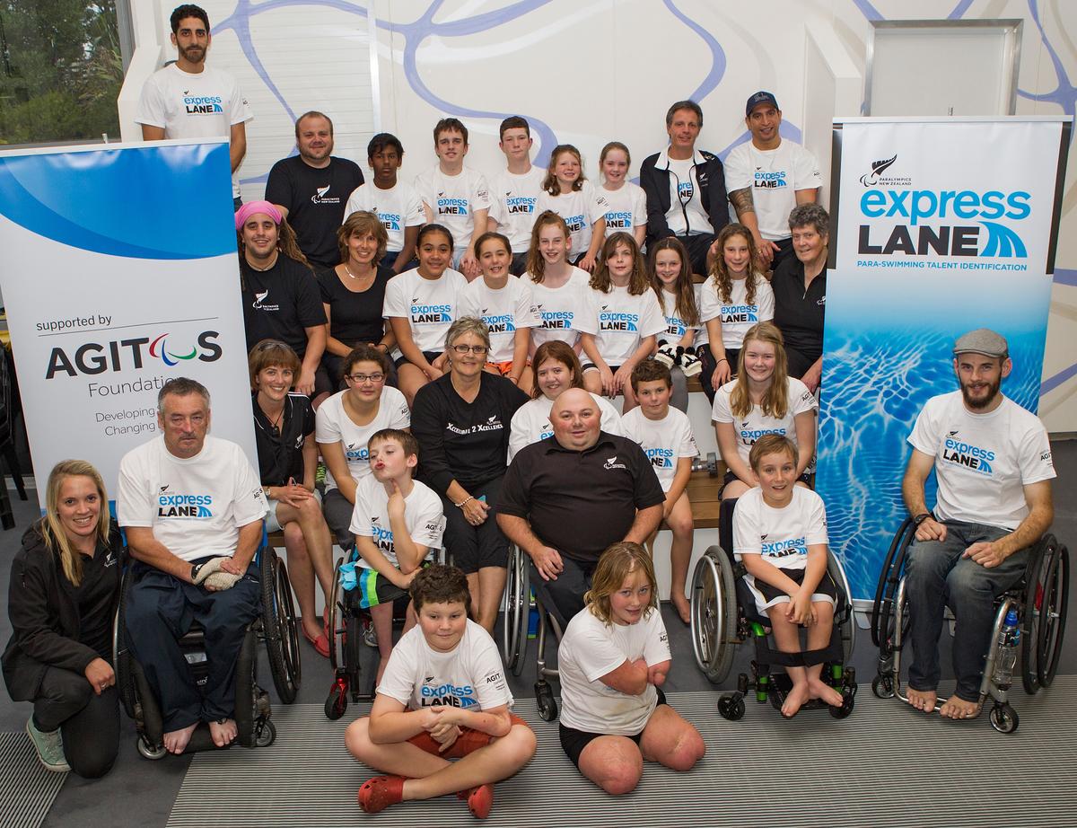 Paralympics New Zeland Talent Identification Swim Camp A group of participants pose in front of Paralympics New Zealand and Agitos Foundation banners.