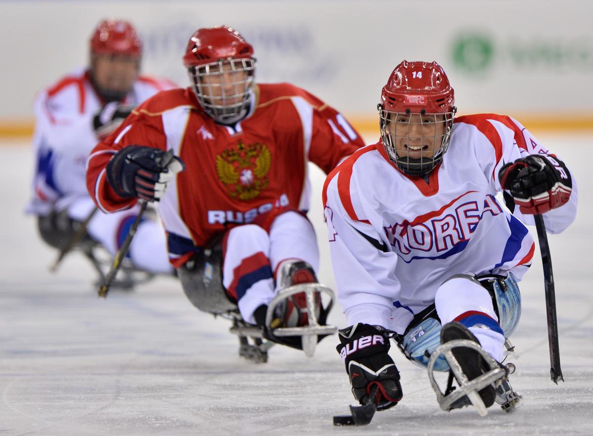Seung-Hwan Jung An ice sledge hockey player scoots up the ice with the puck.