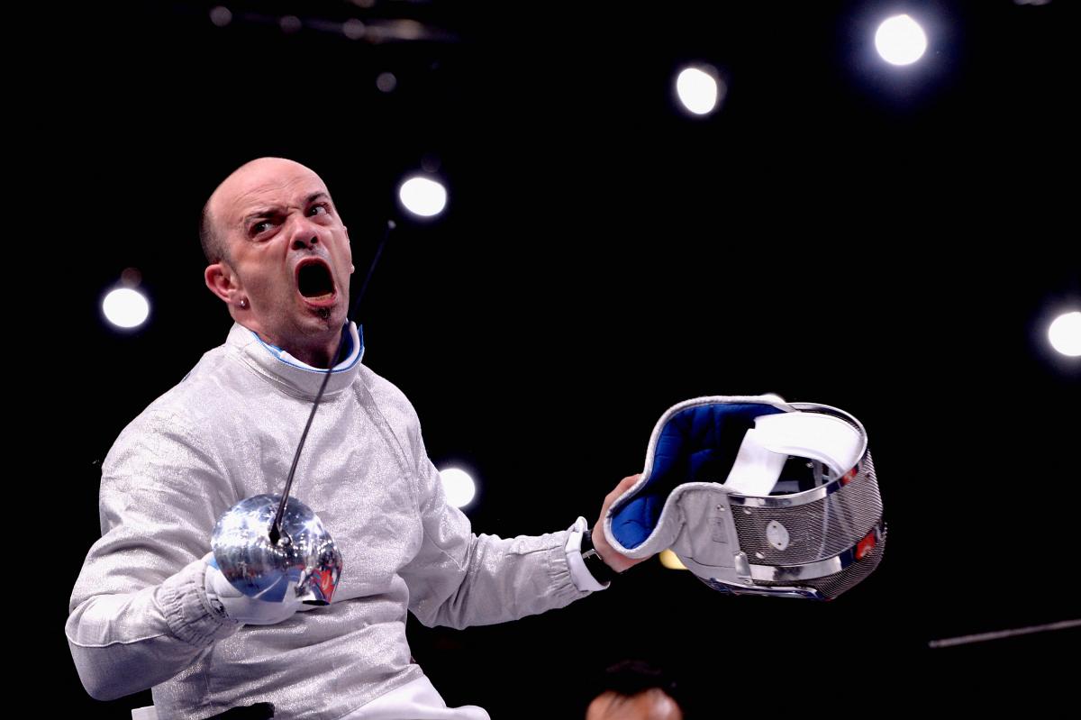 A wheelchair fencer celebrates after a victory.