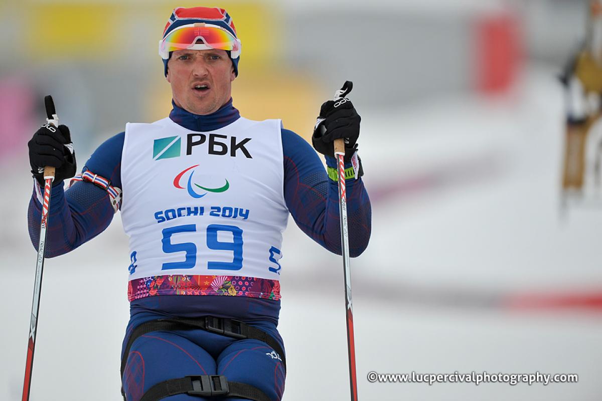 Trygve Steinar Larsen - Sochi 2014 Winter Paralympic Games Close up of torso of sit skier driving forward through the snow with ski poles