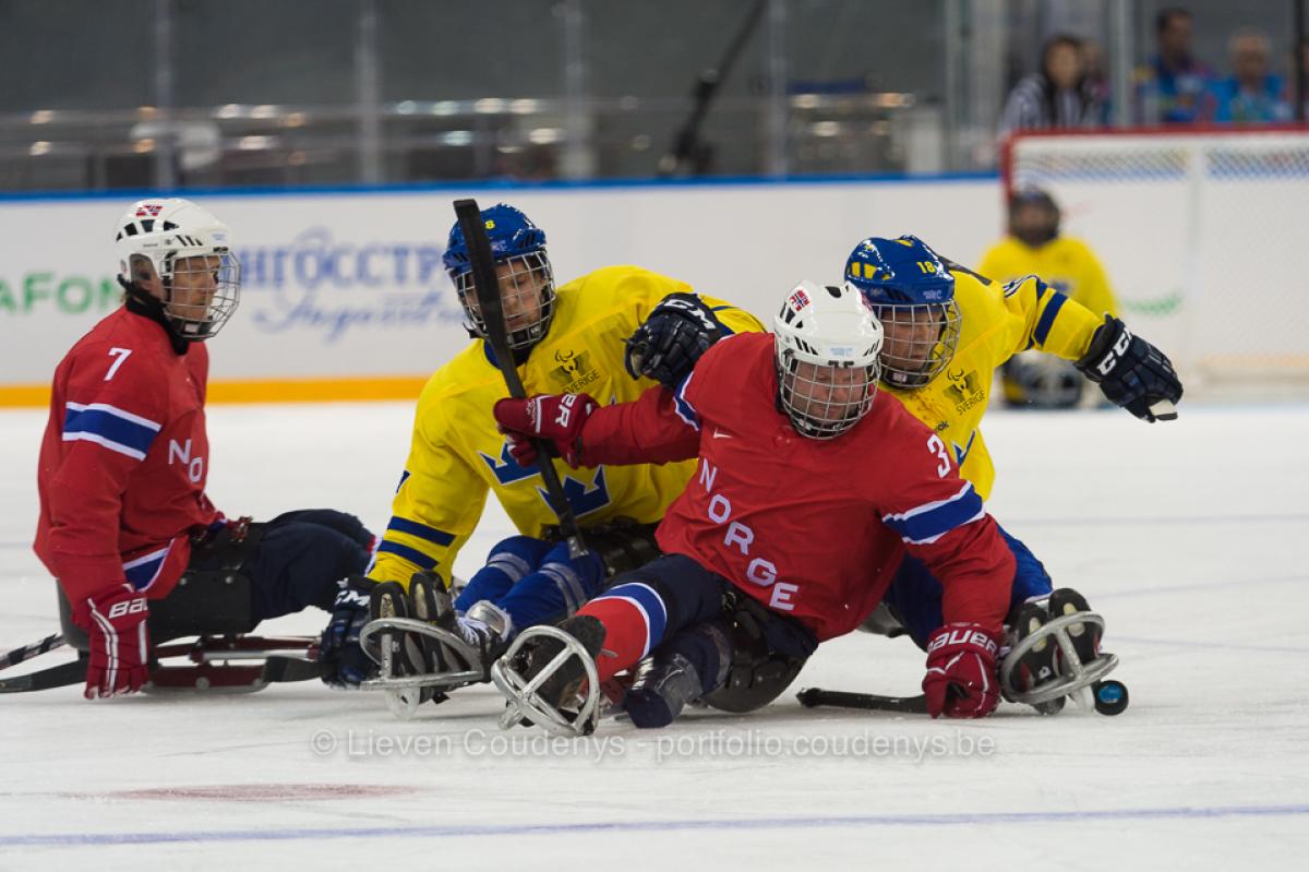 NOR vs. SWE Norweigen player Rolf Einar Pedersen defends puck against two Sweedish players