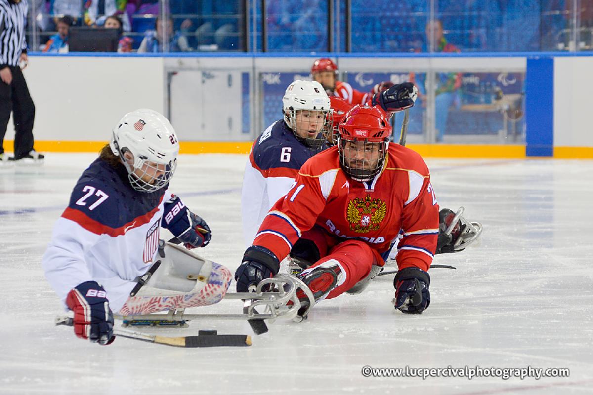 Evgeny Petrov tries to steal puck off Joshua Pauls