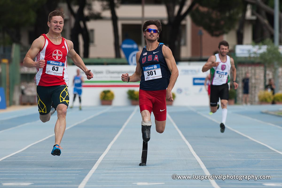 Three sprinters run on a blue track