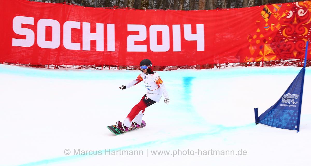 Michelle Salt, Canada flys by a gate in the first ever Women's Para Snowboarding Cross in the Winter Paralympic Games
