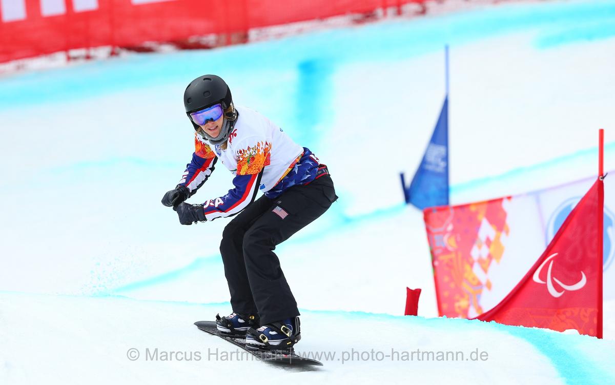 Amy Purdy going over a hill in the snowboard cross course in Rosa Khutor.