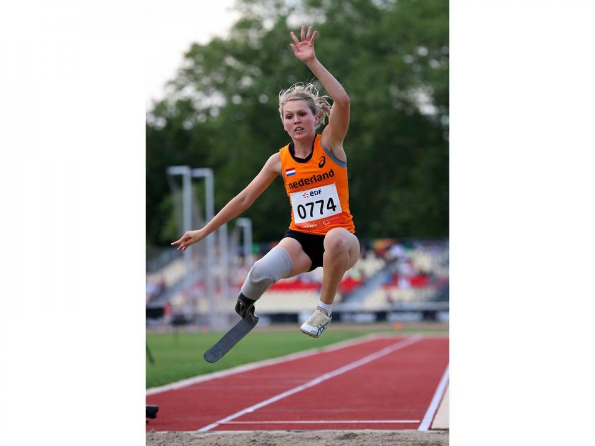 Blod women in orange jersey performing a long jump