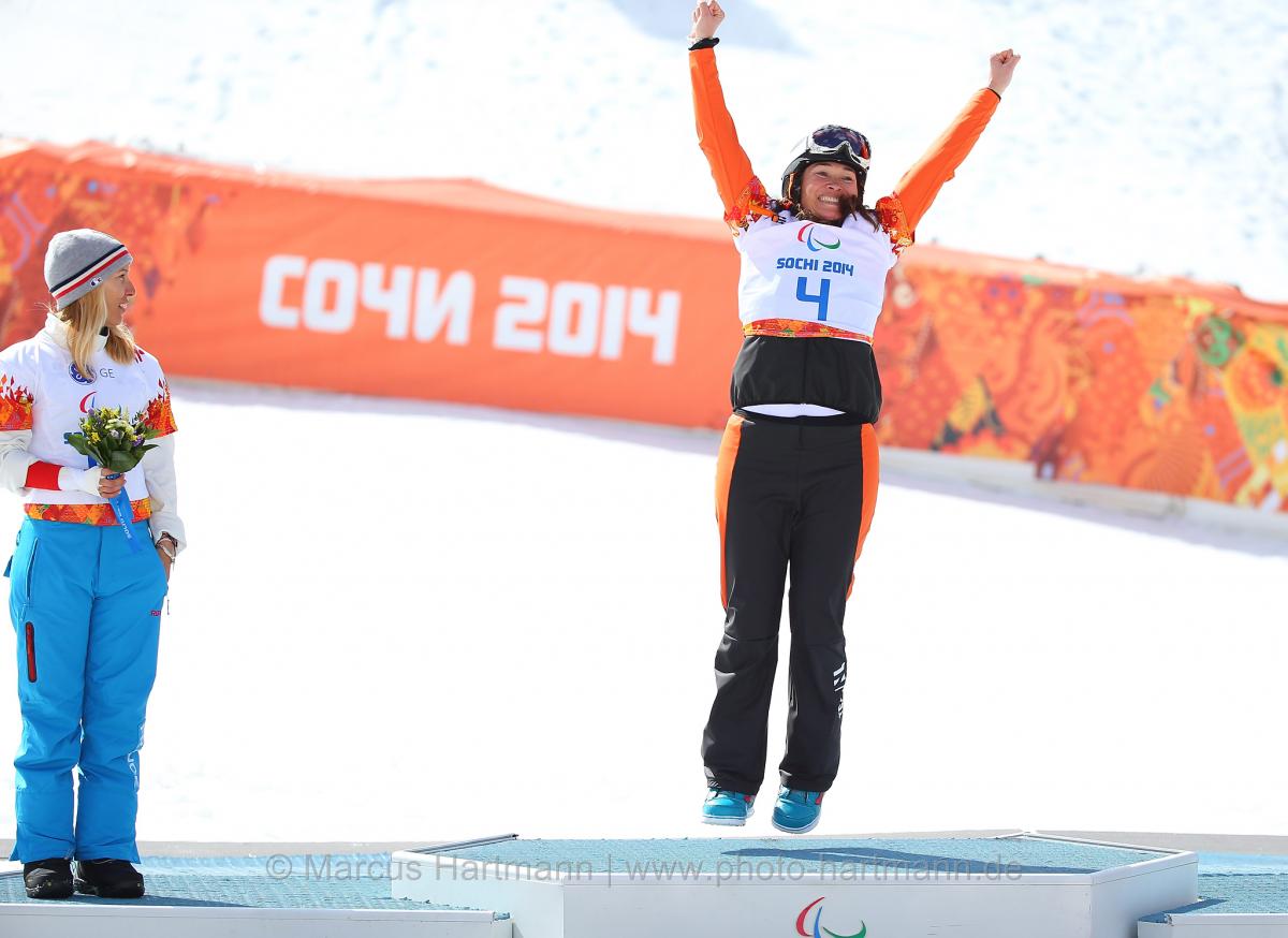 Bibian Mentel-Spee holds her arms high on the podium at the flower ceremony