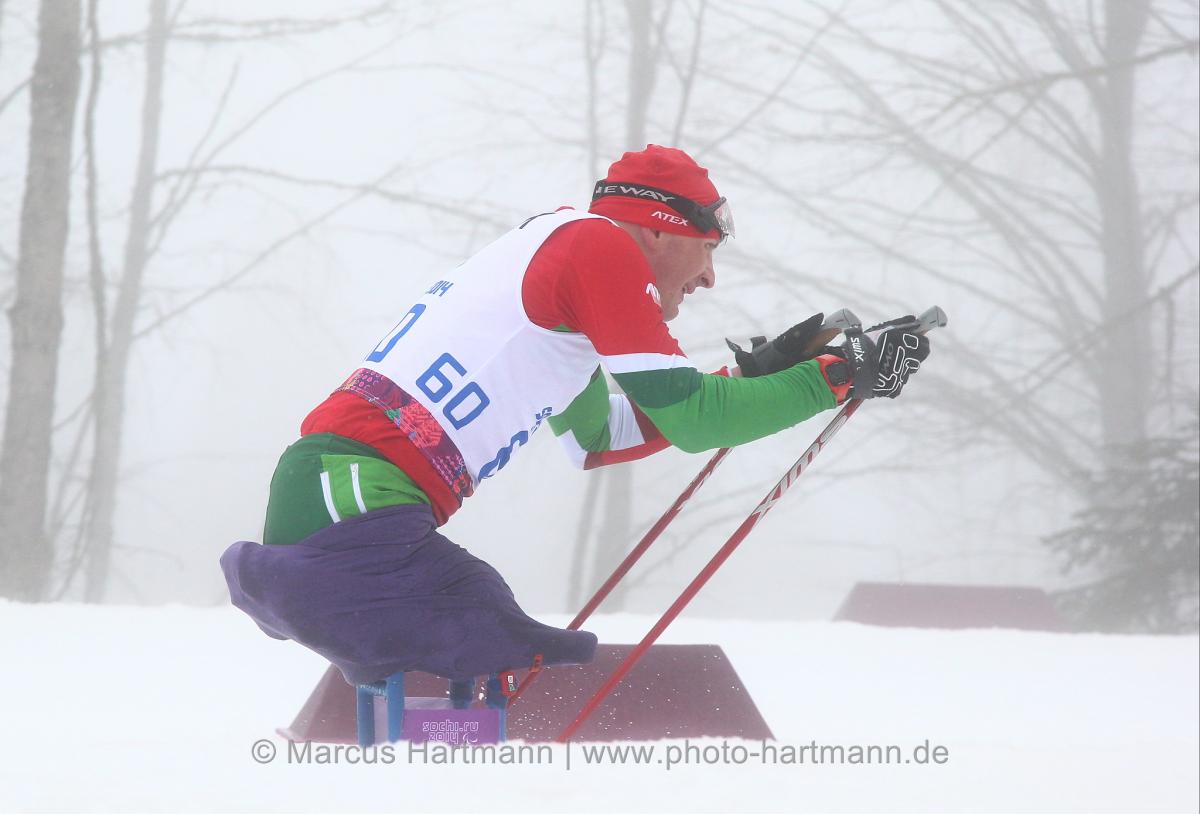 a male Para skier plants his poles in the snow