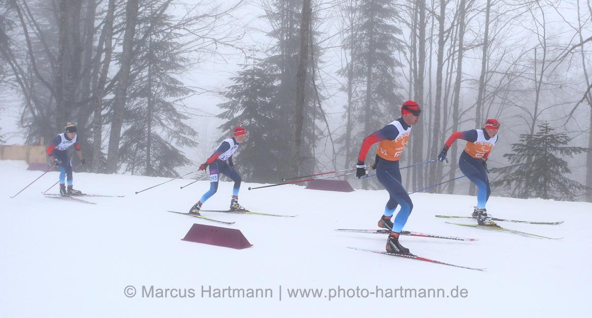 Four people do cross-country skiing on slopes