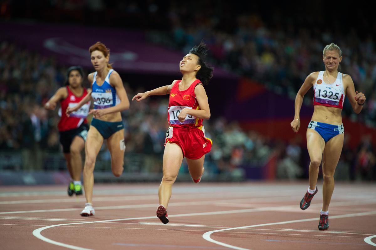 Four runners on a track in a stadium