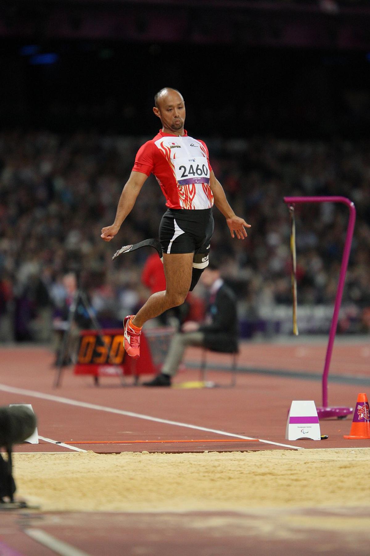 Man with prosthetic leg jumping in a stadium