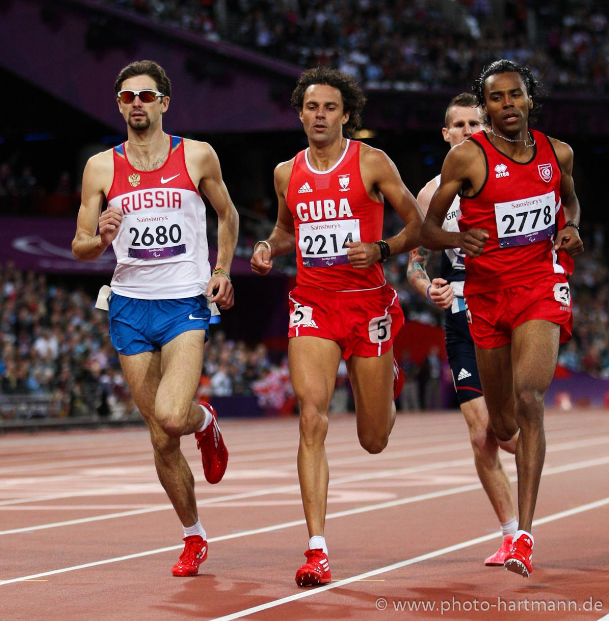 Egor SHAROV, - Athletics - London 2012 Paralympic Games Four runners dressed in shorts and vest competing on a red athletics track.