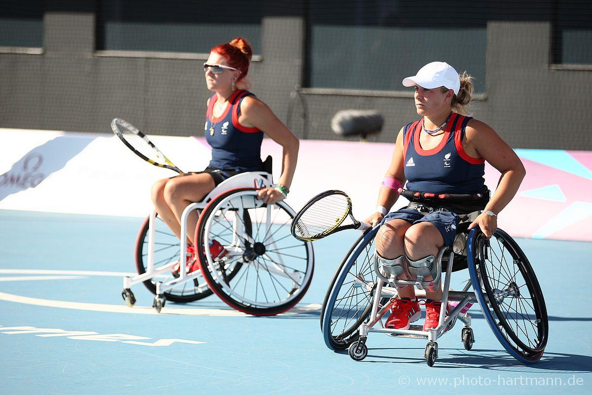 Two women in wheelchairs with tennis rackets during a match