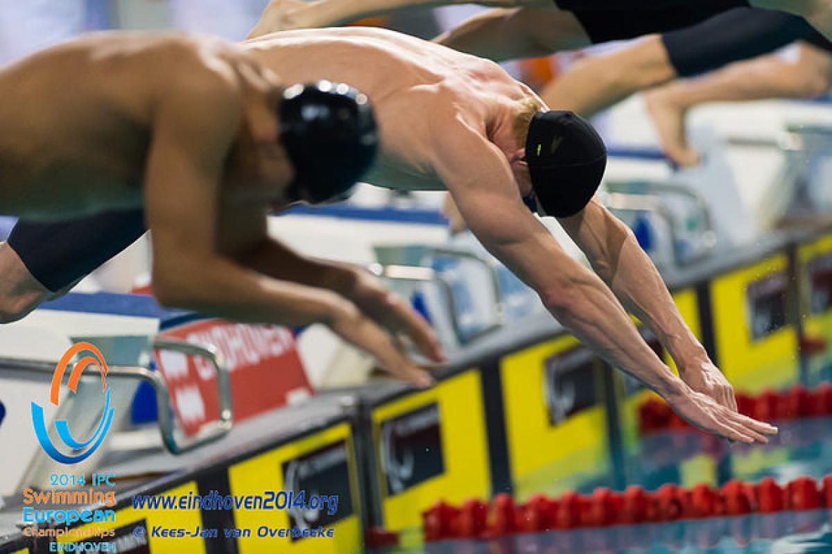Male swimmers start a race at the 2014 IPC Swimming European Championships