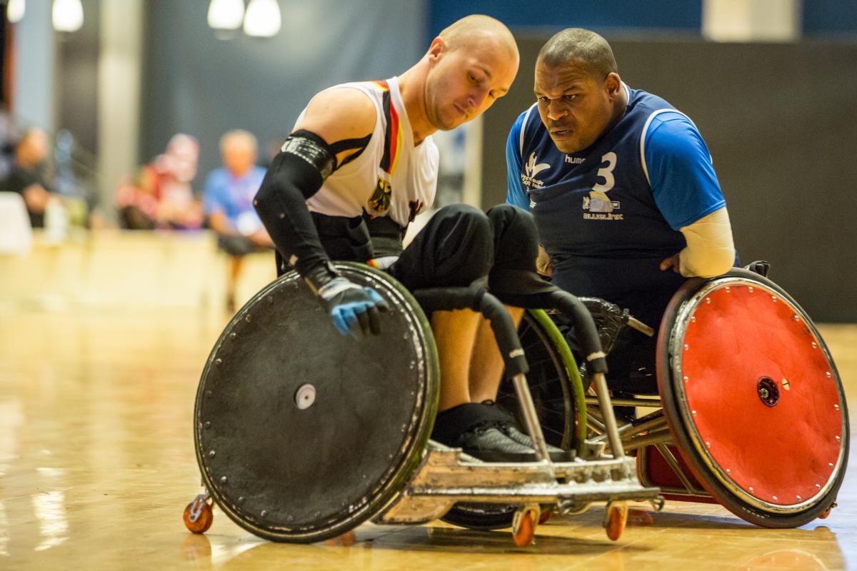 A French player wearing blue collides with his German opponent during a wheelchair rugby game.