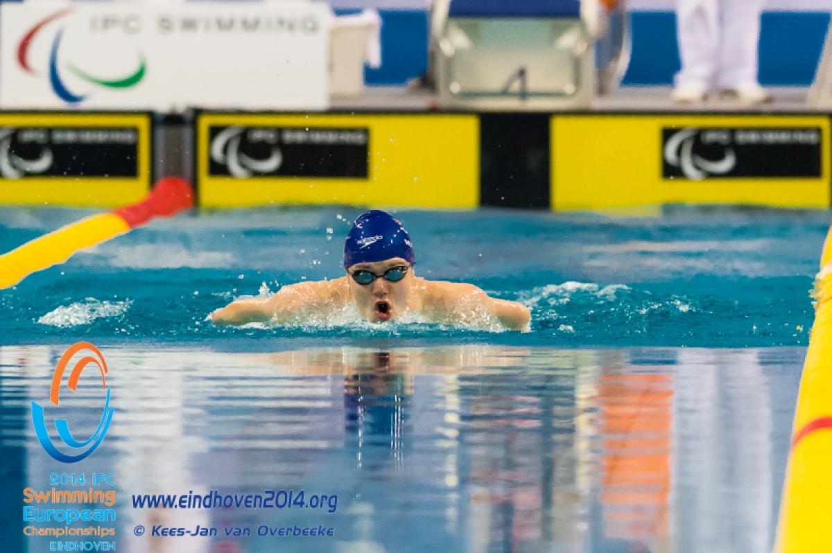 A swimmers emerges from the water to begin a stroke