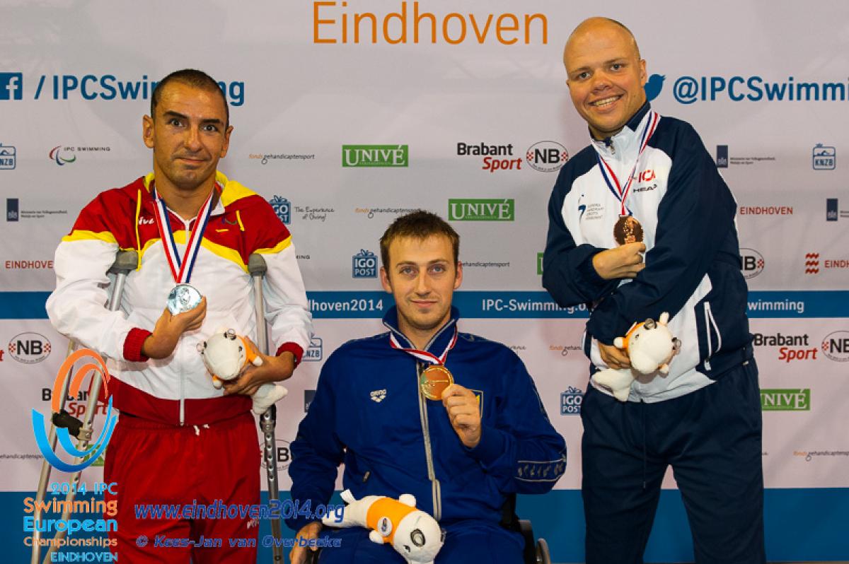 Dmytro Vynohradets poses with his latest gold medal alongside the silver and bronze medal winners at the 2014 IPC Swimming European Championships.