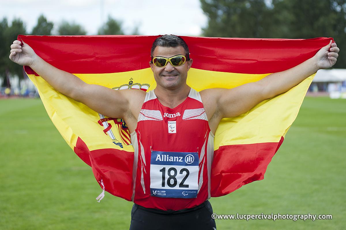 David Casino Discus F11 winner at Swansea Man with a spanish flag celebrating on a field of play in a stadium