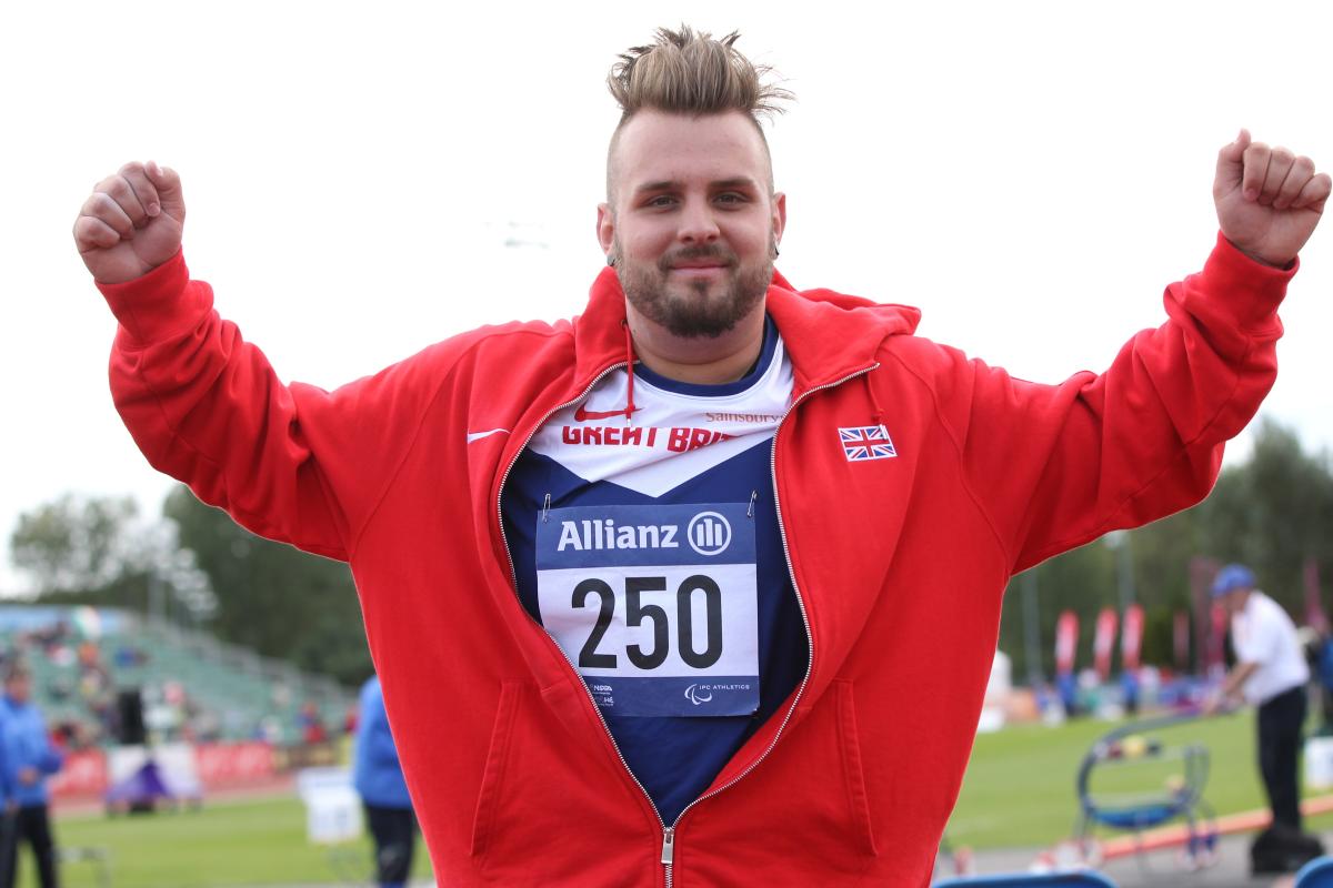 Man celebrating, wearing a red jacket