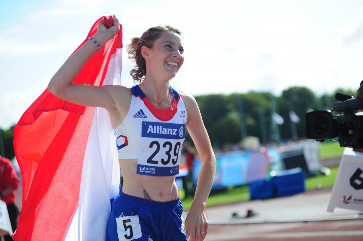 Women on a track celebrating with a French flag