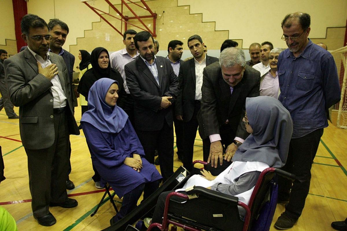 Men in suits in a conversation with two women in wheelchairs