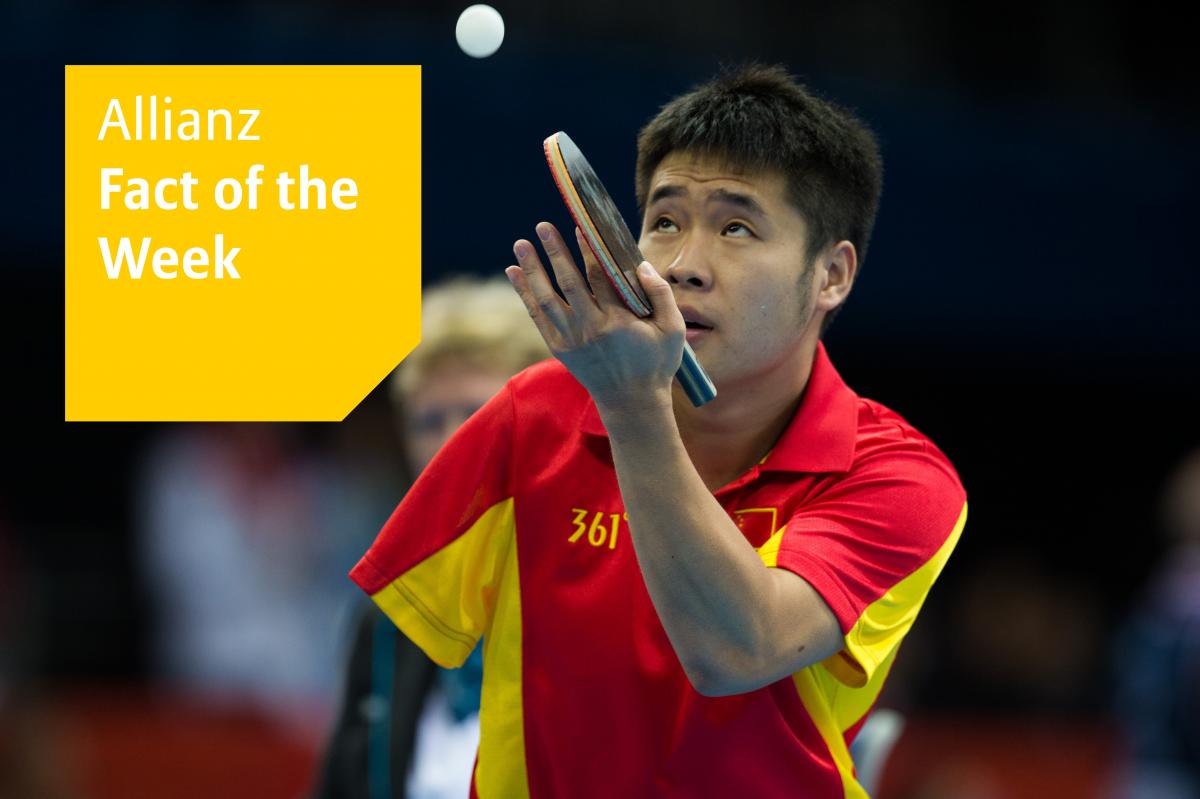 A one-armed Chinese table tennis player about to serve, watching the ball.