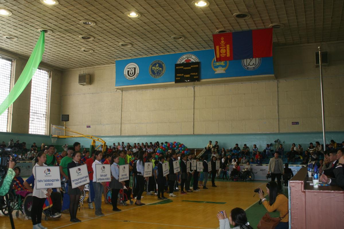 Many people in a room with some holding white signs