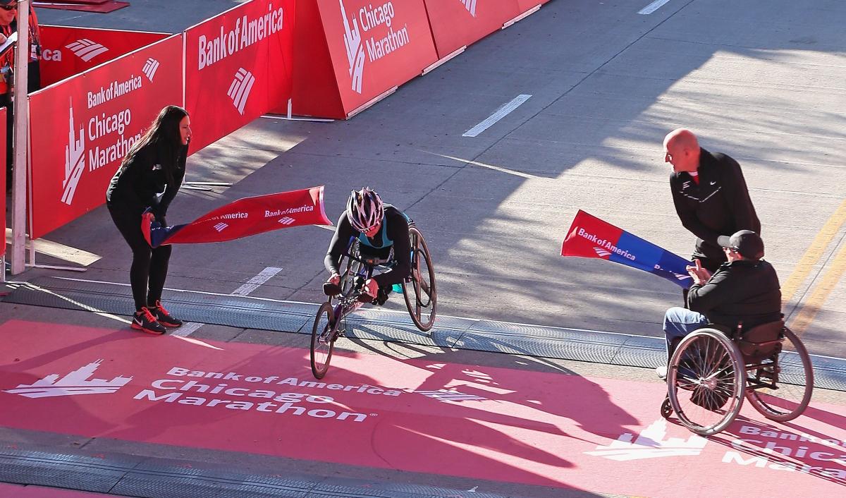 Tatyana McFadden wins 2014 Chicago Marathon Women in racing wheelchair crossing a finish line