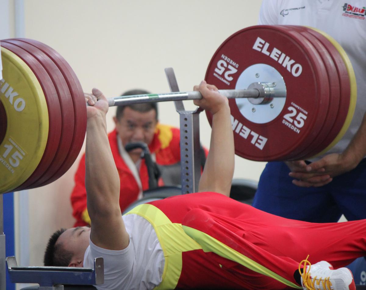 Chinese powerlifter Lei Liu Powerlifter on a bench lifting a bar