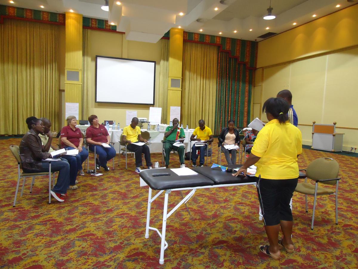 10 people in a workshop around a table with one person explaining.