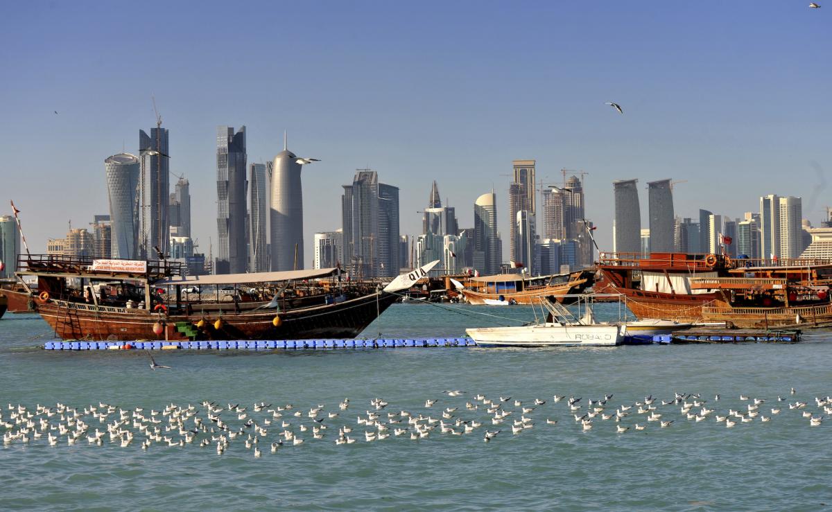 Wooden boat in the water, skyscrapers in the background