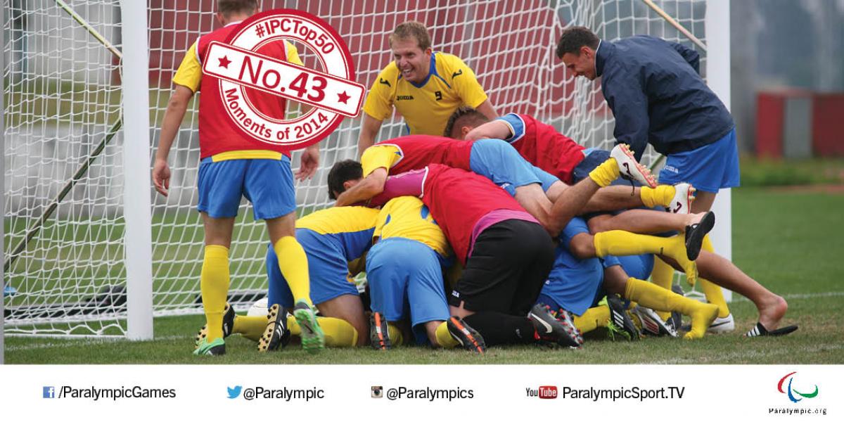 Players celebrate, jumping one on another on a football field of play