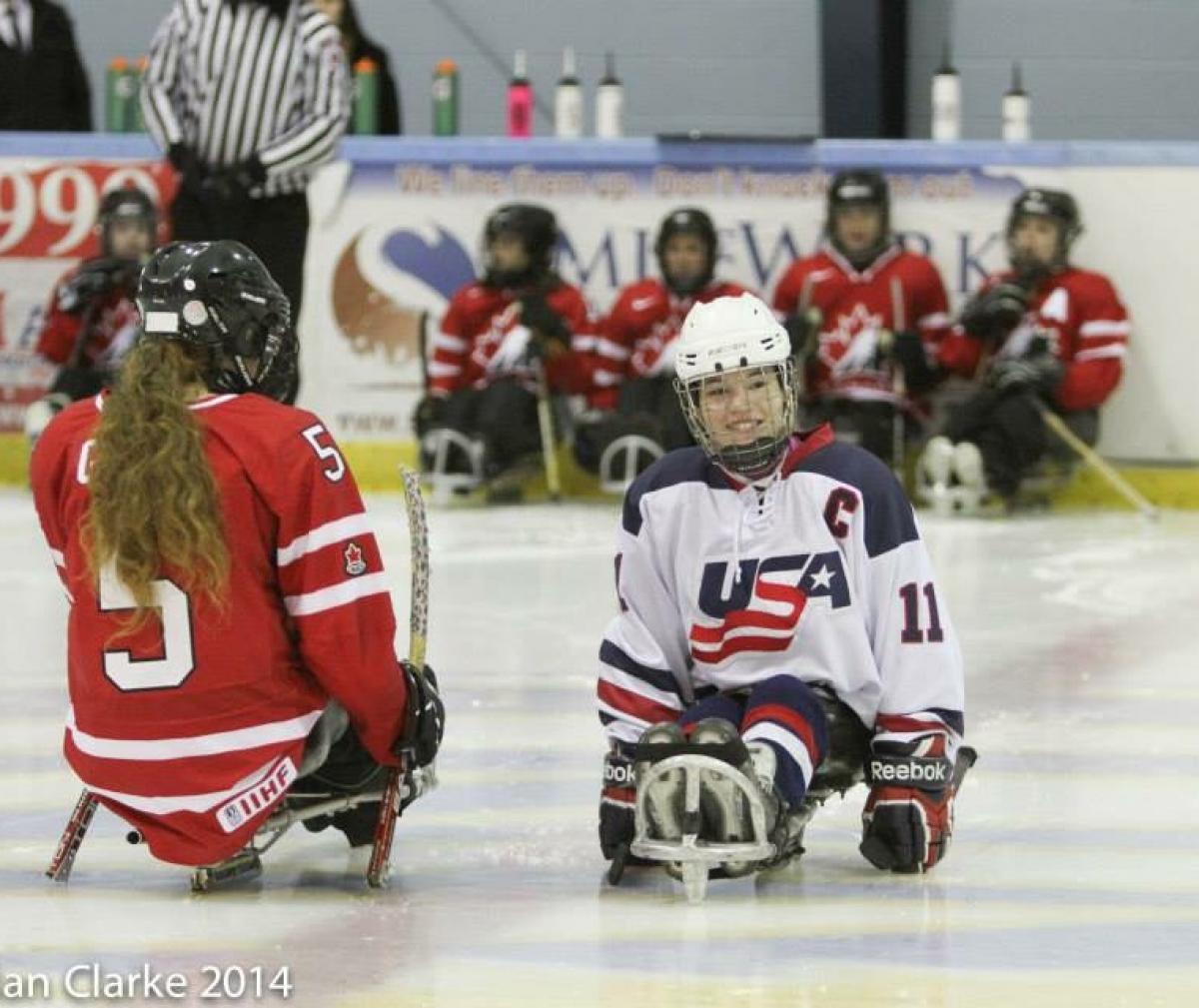 Young girl in a sled on the ice, smiling to the camera