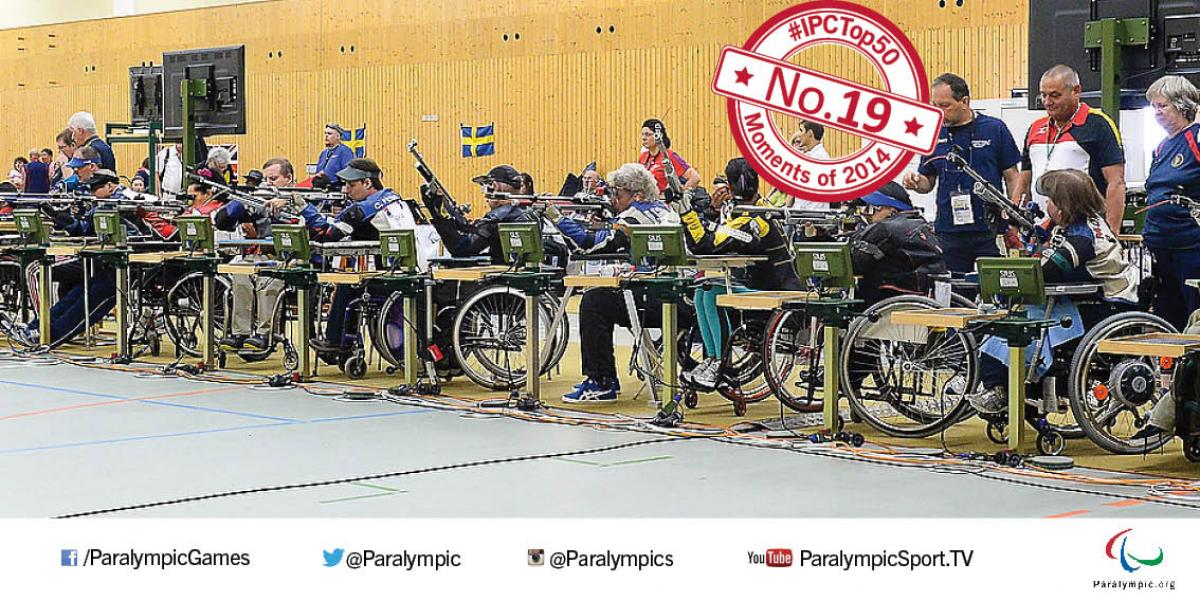 19. IPC Shooting A line of seated athletes holding rifles line up for competition.