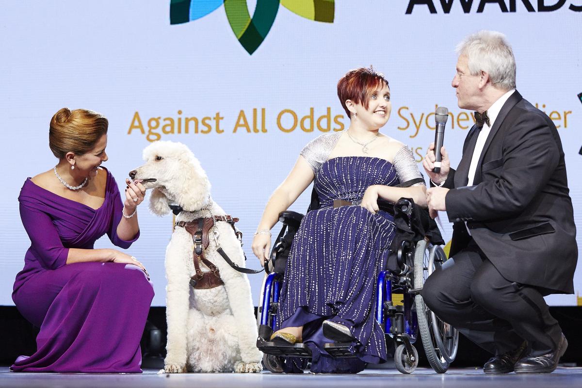 Sydney Collier and her service dog Journey receive the 2014 FEI Against All Odds award.