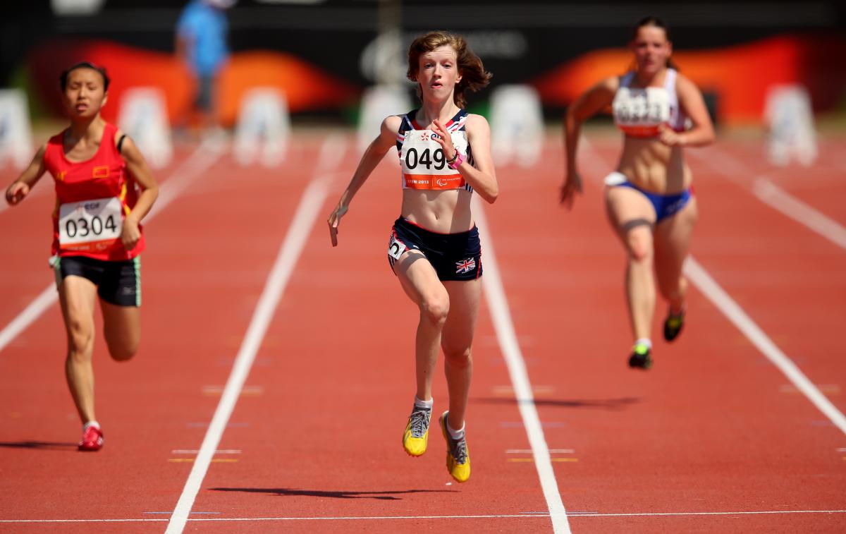 Women run on the finish line of a stadium