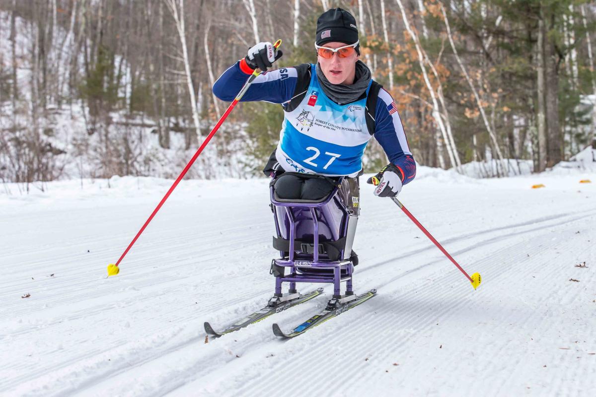 Women in sit ski on snow