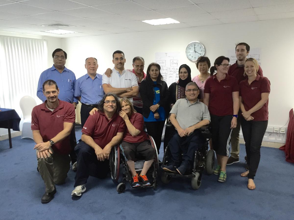 Group picture of people standing sitting and sitting in wheelchairs