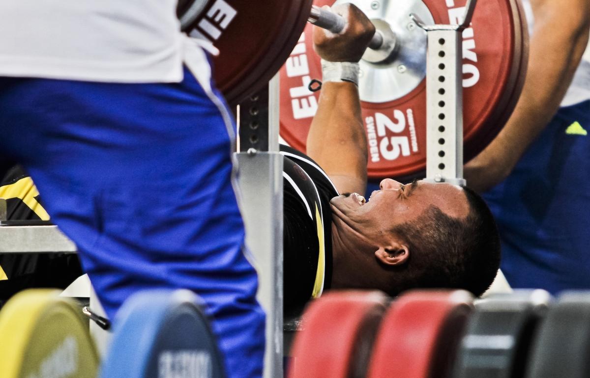 A powerlifter tries to lift the bar.