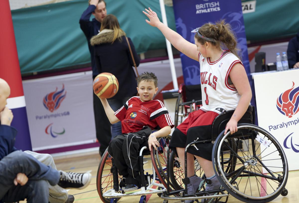Two people in wheelchair playing basketball