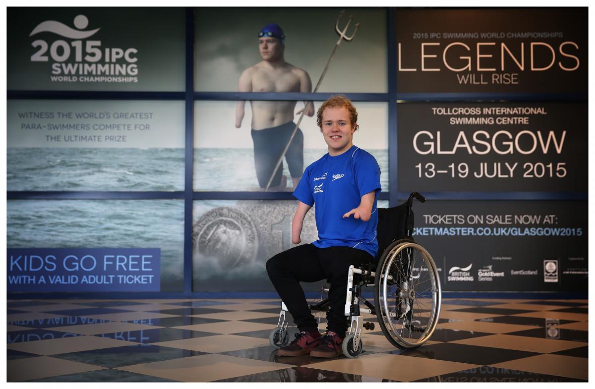 Andy Mullen Promotional Campaign Glasgow Man in wheelchair poses in front of a wallpaper
